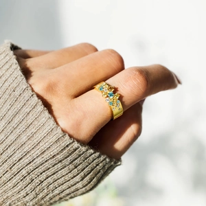 Bague élégante en argent S925 plaqué or ornée de zircons colorés sur le doigt d'une femme