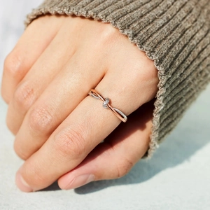 Détail de la bague nœud bicolore en argent S925 sertie de pierres au doigt