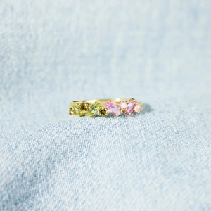 S925 sterling silver ring with marquise pink and green stones on denim background
