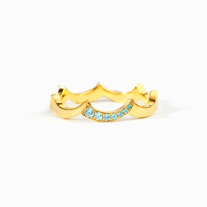 Polished gold wavy s925 silver ring with small blue crystals on a clean white background