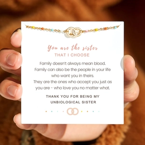 Detail of colorful beaded gold necklace with interlocking rings on friendship card