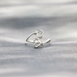 Macro shot of 925 sterling silver adjustable double heart open ring on fabric