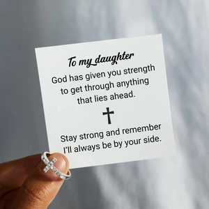Detail of s925 silver cross ring with cubic zirconia next to a meaningful gift card