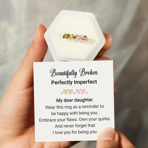 Detail of s925 gold ring with pink and olive gems in a velvet box with a message card