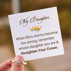 Golden crown ring with blue stones held against an inspirational gift card for daughter
