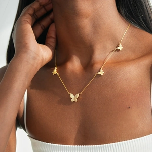 Élégant collier ras du cou papillon doré serti de zircons porté par un mannequin