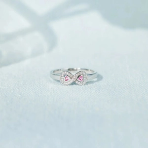 Macro shot of silver infinity ring with pink heart stones and micro-pave zircons