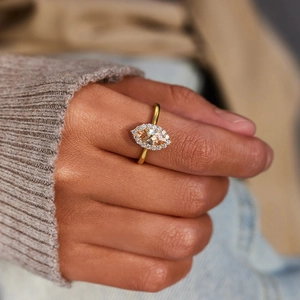Close-up of marquise-cut champagne zircon ring with halo setting on a model's finger