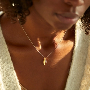 Elegant mixed-tone S925 silver leaf feather pendant necklace worn by a female model