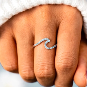 Minimalist s925 silver wave ring with blue zircon stones on a female hand model
