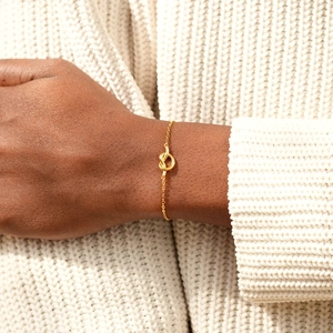 Minimalist S925 sterling silver heart knot gold bracelet worn on a female wrist