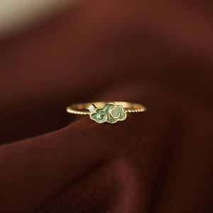 Macro detail of S925 silver ring featuring green enamel cloud and zircon on gold band