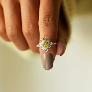 Close-up of S925 silver flower ring with yellow gemstone and heart-shaped hollow petals