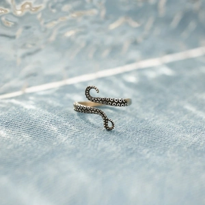 Detailed close-up of S925 sterling silver octopus tentacle ring on denim background