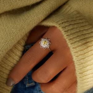 Detailed view of S925 sterling silver ring with yellow flower stone worn on index finger