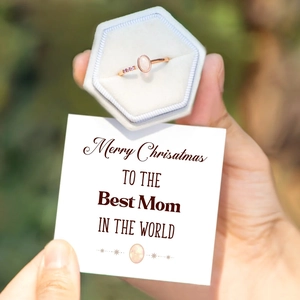 Rose gold opal ring with pink side diamonds in a gray hexagonal velvet jewelry gift box