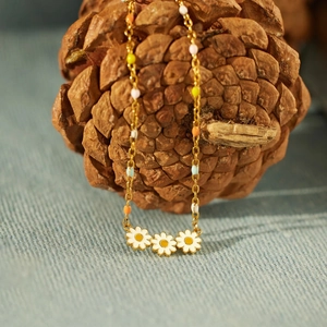 Detail of s925 silver daisy pendant with colorful enamel beads and golden chain