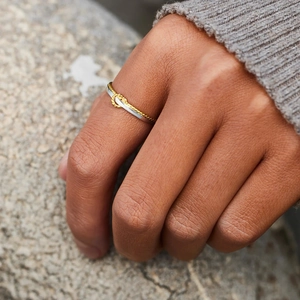Bague noeud bicolore en argent sterling S925 portée par un mannequin sur fond texturé