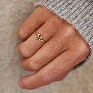 Minimalist S925 silver ring featuring gold infinity knot and heart design on finger
