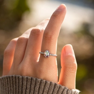 Bague en argent S925 avec topaze mystique ovale portée sur un doigt féminin