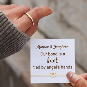 Détail d'une bague nœud bicolore avec une carte de message Mère et Fille
