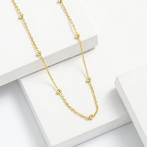 Minimalist S925 sterling silver golden satellite bead necklace shown on white cubes