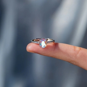 Détail d'une bague perlée en argent s925 avec une pierre ovale mystique effet aurora