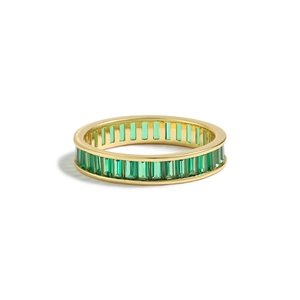 Macro view of gold ring with emerald-green baguette cut stones in channel setting