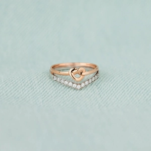 Detail of rose gold heart knot ring layered with a V-shaped sparkling zircon band