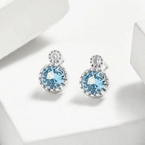 Détail macro de boucles d'oreilles en argent S925 avec zircon bleu et pierres