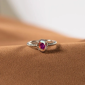 Détail macro d'une bague en argent s925 avec pierre irisée et bordure perlée