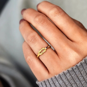 Detailed view of an S925 silver knot ring featuring three colored gemstones on a finger