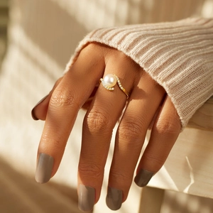 Elegant gold S925 silver ring with white pearl and sparkling pavé crystals worn by a model