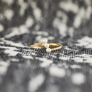 Elegant gold S925 silver ring with three pearls and sparkling zircon accents on tweed