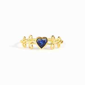 Bague élégante en or avec pierre précieuse bleue en forme de cœur et détails de ruban