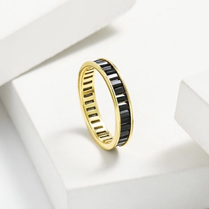 Detail of eternity band featuring baguette-cut black stones set in polished gold plating