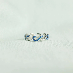 Detailed view of S925 silver wave ring with blue cubic zirconia in a pave setting