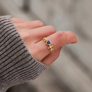 Bague élégante en or avec une pierre bleue en forme de cœur et motifs papillons