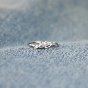 Minimalist S925 sterling silver ring featuring a sparkling zircon leaf design on denim
