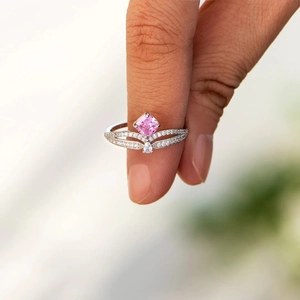 Detailed macro of a silver crown ring featuring a square pink zircon and pavé band