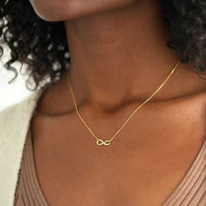 Elegant s925 silver infinity necklace in gold with sparkling diamonds on a woman neck