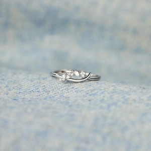 Macro detail of S925 silver cross leaf ring with marquise and round cubic zirconia stones