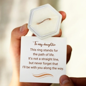 Detail of rose gold wavy stacking ring with diamonds in a white velvet jewelry box