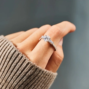 S925 sterling silver ring with oval cut center stone and side accents on hand