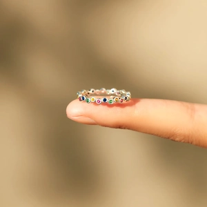 Close-up of multicolor rainbow eternity ring with vibrant gemstones on a silver band