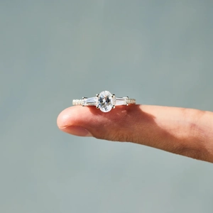 Detailed close-up of a three-stone S925 silver ring featuring an oval center stone and side gems