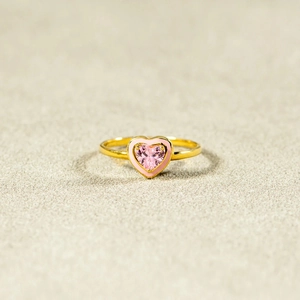 S925 silver heart ring with pink gemstone and pink enamel on a textured stone surface