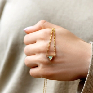 Handheld view of a S925 silver triangle opal necklace with gold plating and blue stone