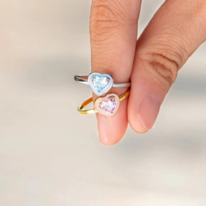 Detail of s925 silver pink and blue enamel heart rings worn on fingers