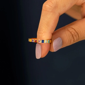Detailed macro view of gold-plated silver ring with square-cut rainbow gemstones